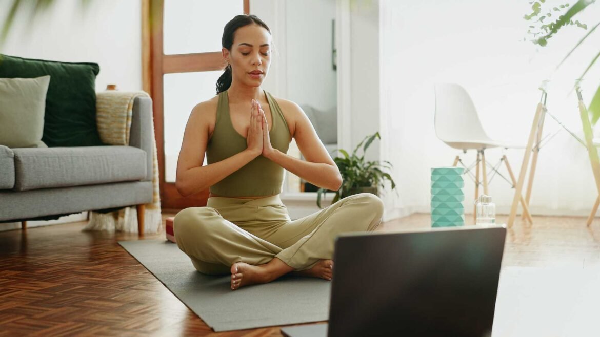Woman meditating at home using a guided mindfulness app to improve emotional resilience