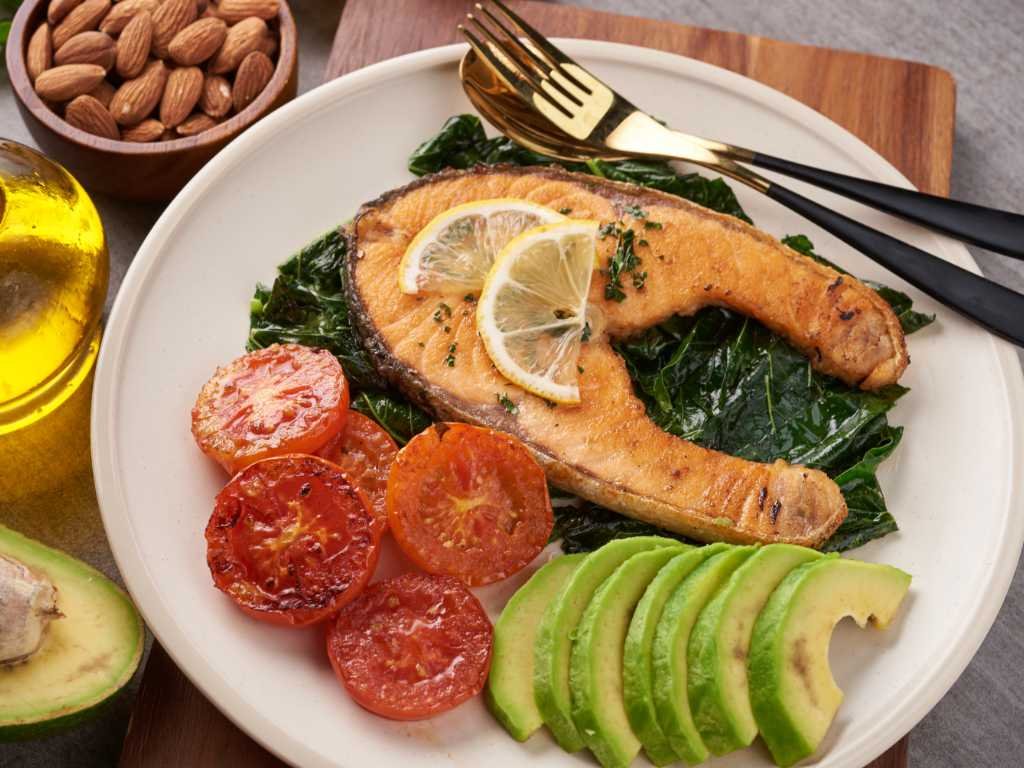 Balanced meal with salmon, avocado, tomatoes, and leafy greens supporting anxiety relief techniques