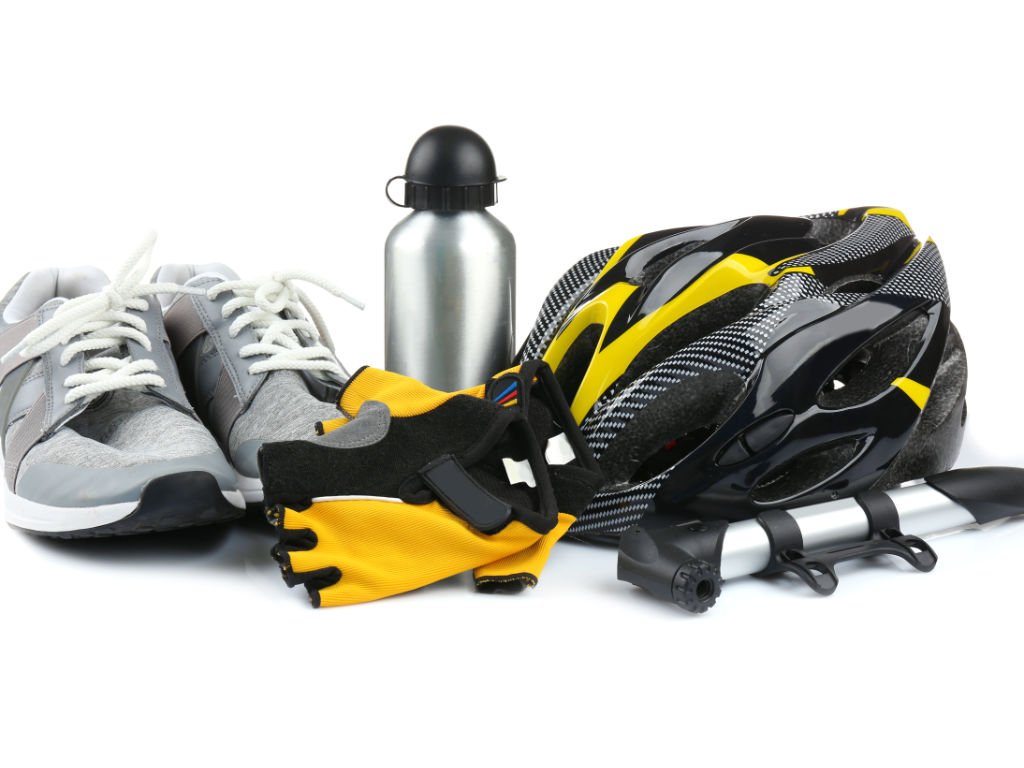 Clean white‑background cycling exercise essentials—helmet, gloves, pump, water bottle, and sneakers
