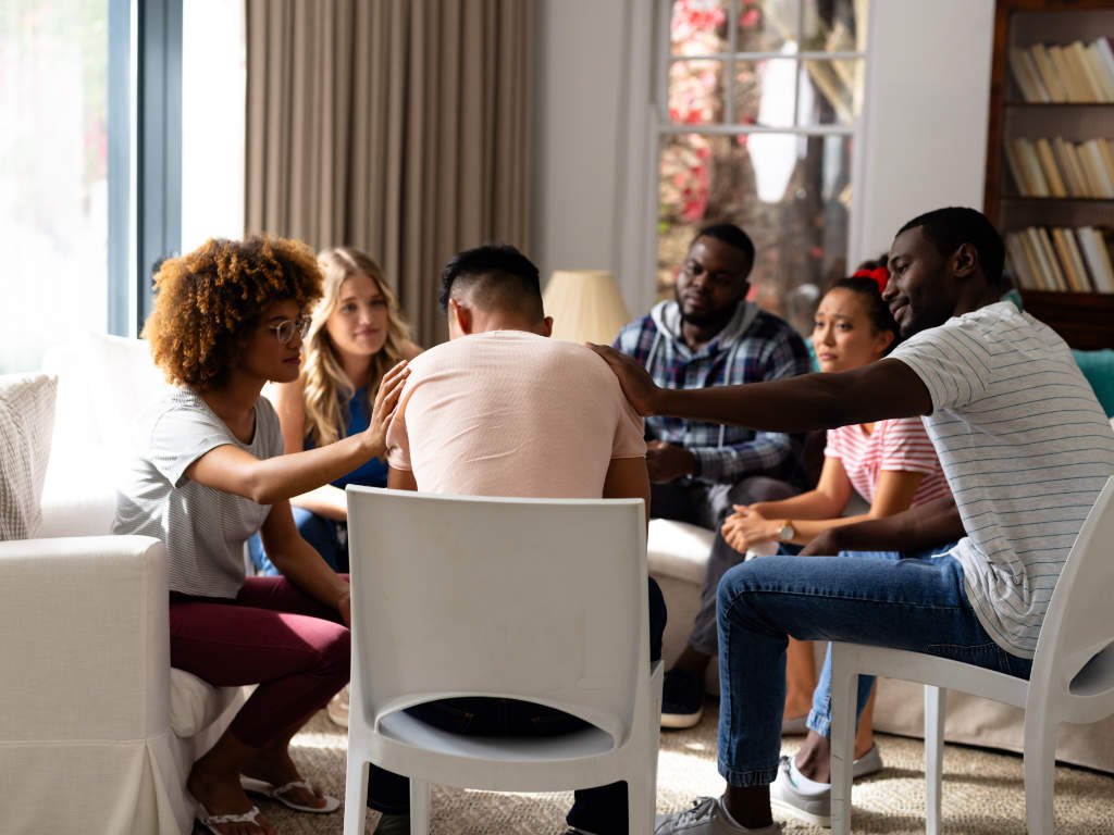 Group of diverse friends offering support during a therapy session, showing the role of social connections in anxiety relief techniques