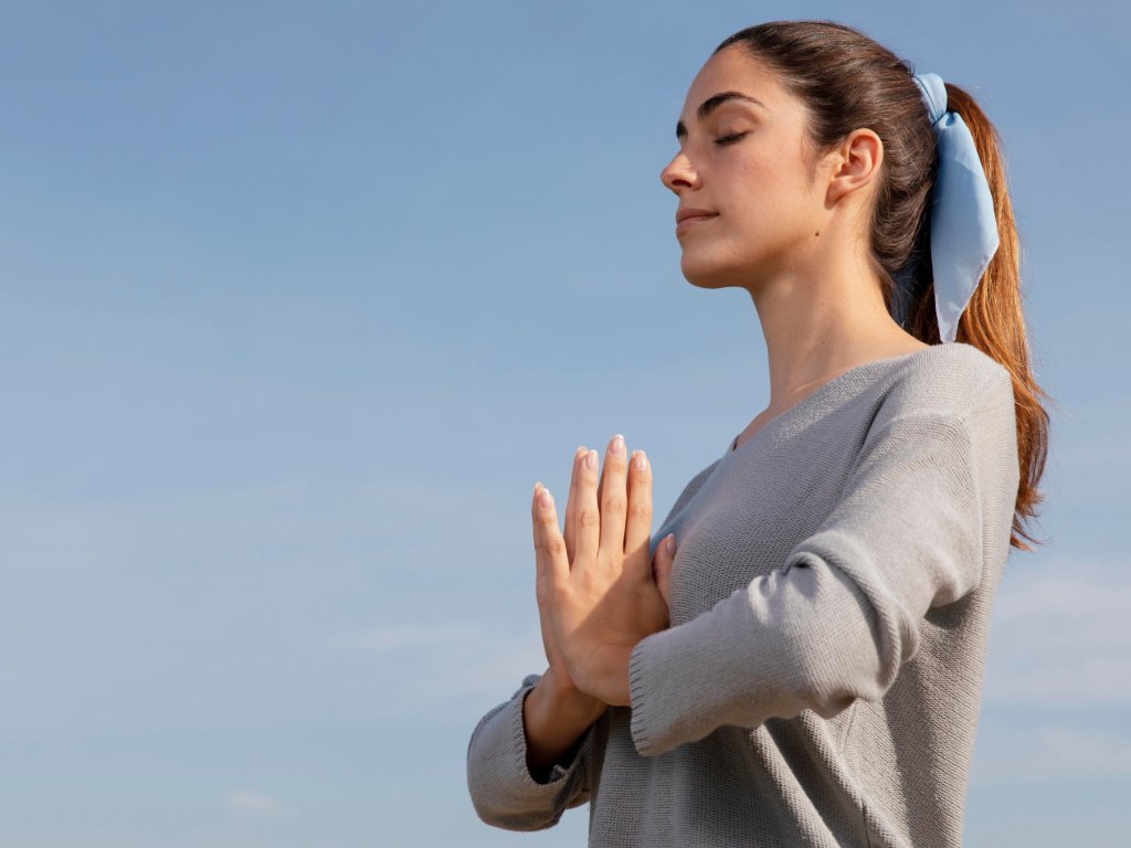 Woman meditating peacefully in nature as part of her emotional wellness plan
