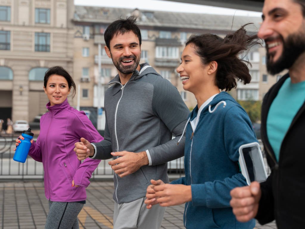 Happy diverse group of friends running together outdoors showing community support and motivation during fitness journey for beginners