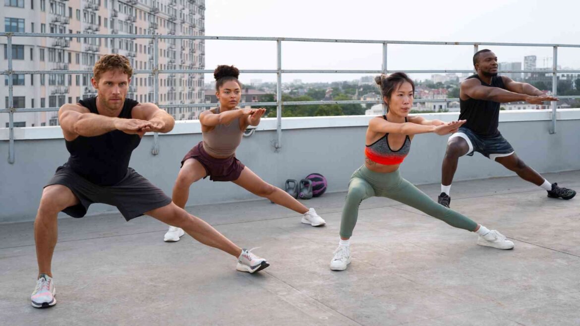 Group of diverse people doing lateral lunges together during their fitness journey workout session on rooftop