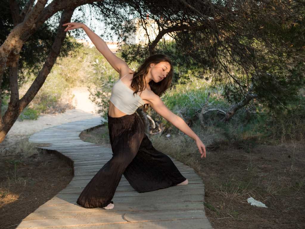 Woman practicing dance movement outdoors as part of holistic beauty routines for natural wellness and inner radiance