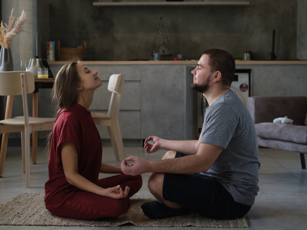 Couple meditating together at home as part of a meaningful routine for emotional wellness