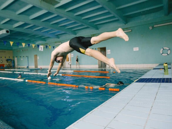 Swimmer diving into pool for interval training session with lane dividers