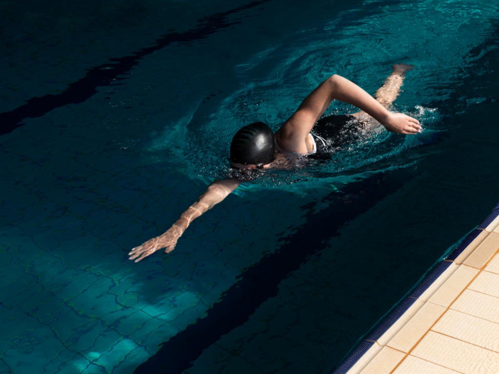 Swimmer performing cardio workouts with freestyle stroke in indoor pool