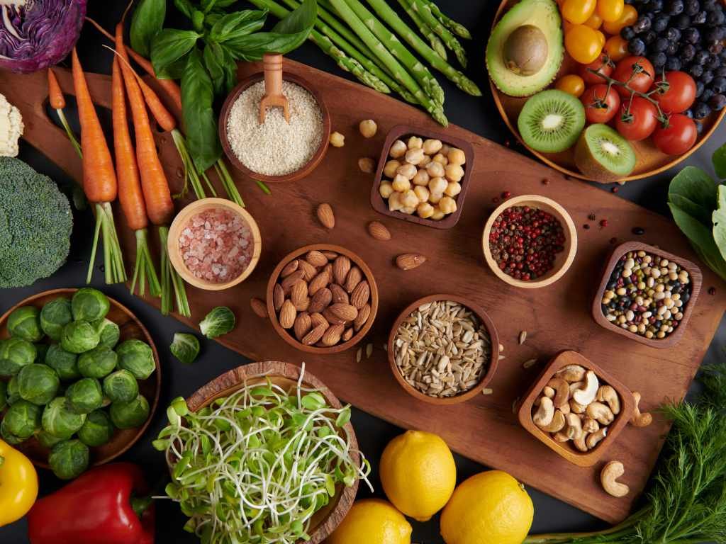 Diverse array of whole foods showcasing healthy eating habits with vegetables, fruits, nuts, and legumes
