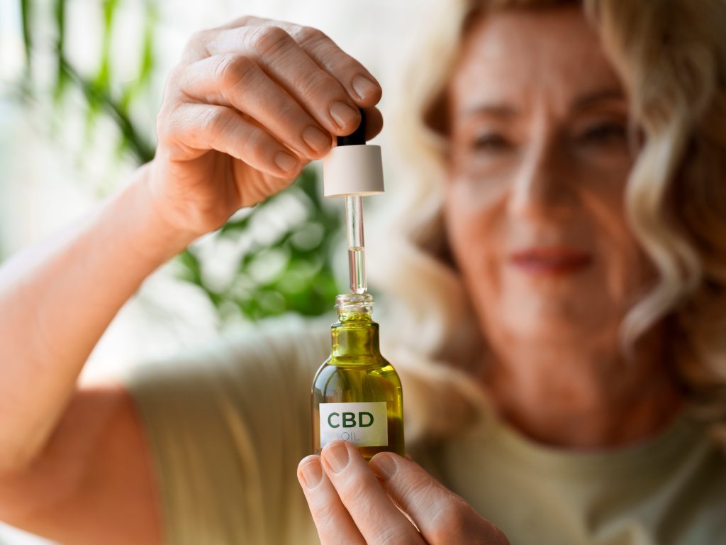 Person using dropper to measure CBD oils for stress relief dosage from bottle