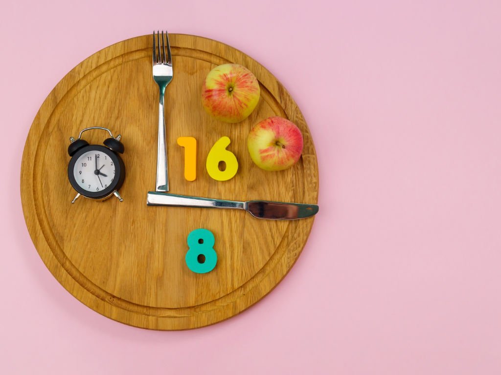 Intermittent fasting 16:8 method clock concept with healthy apples to boost your metabolism and accelerate weight loss