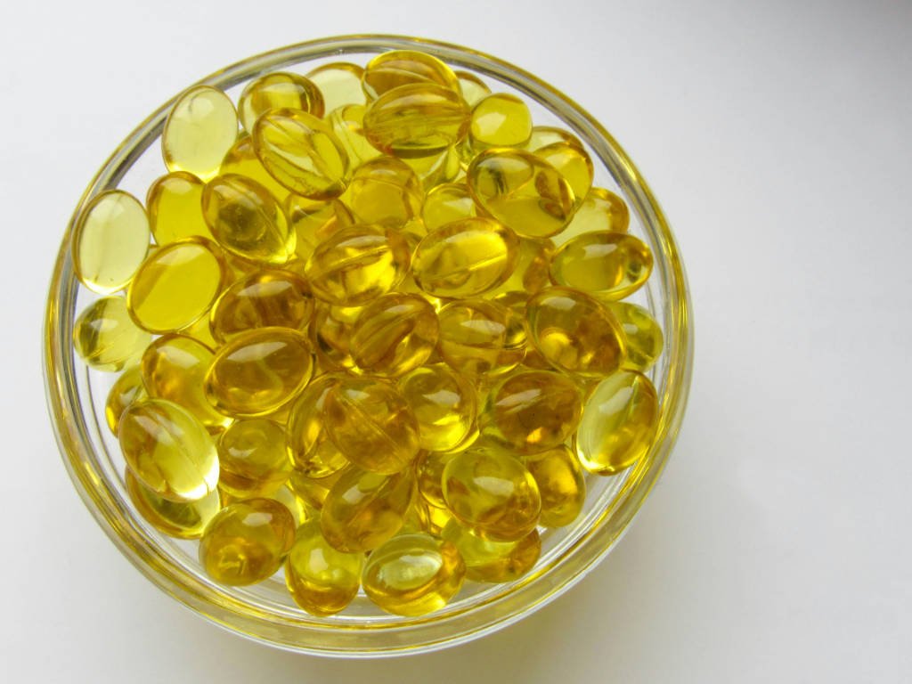 Golden omega-3 capsules in glass bowl showcasing natural anti-inflammatory benefits for heart health and inflammation reduction