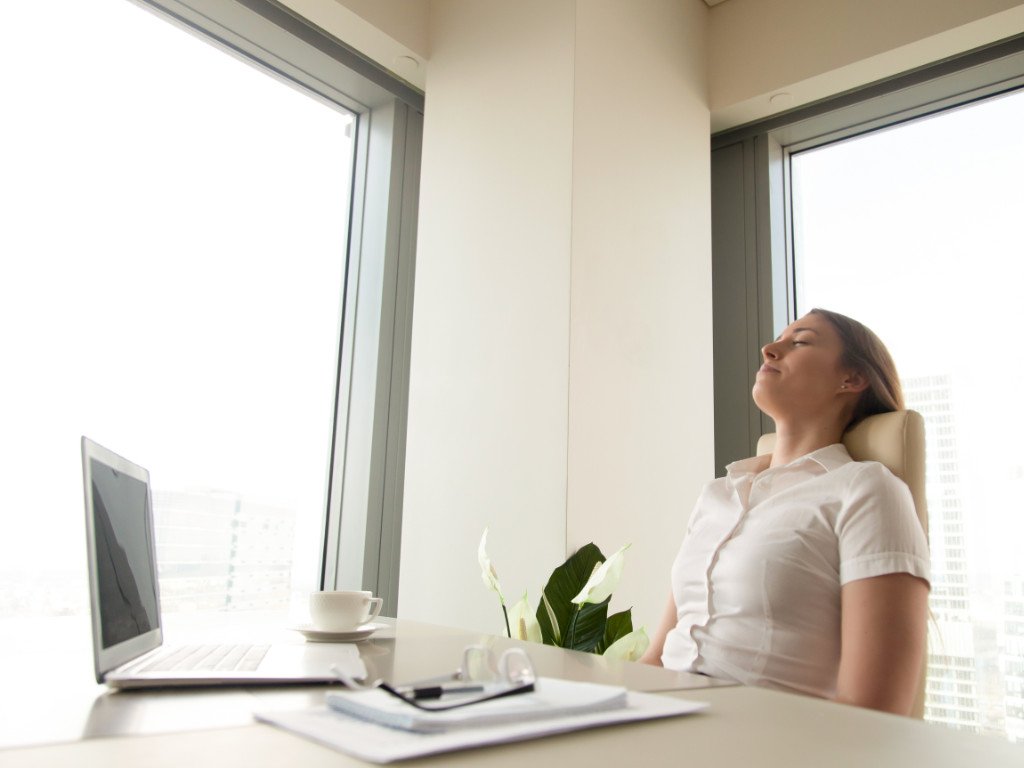 Professional taking mindful breathing break demonstrating mindful meditation benefits for overcoming time constraints