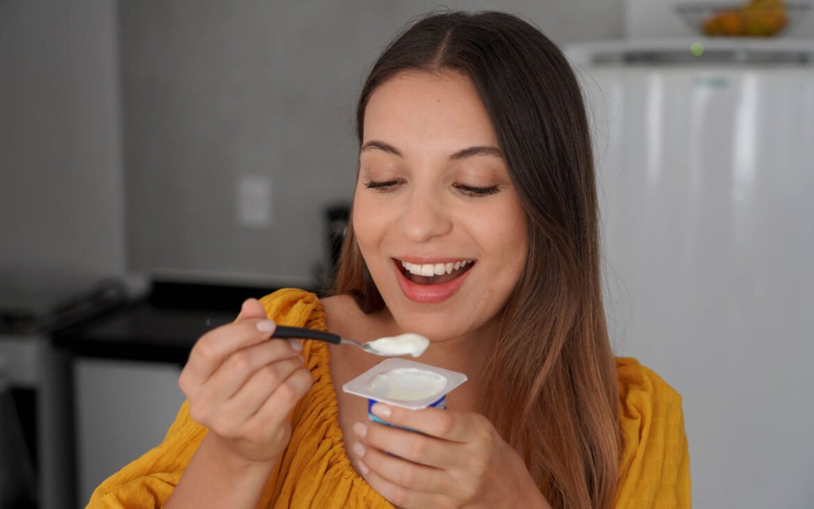 Woman enjoying probiotic-rich yogurt in a kitchen setting – Probiotics for Women