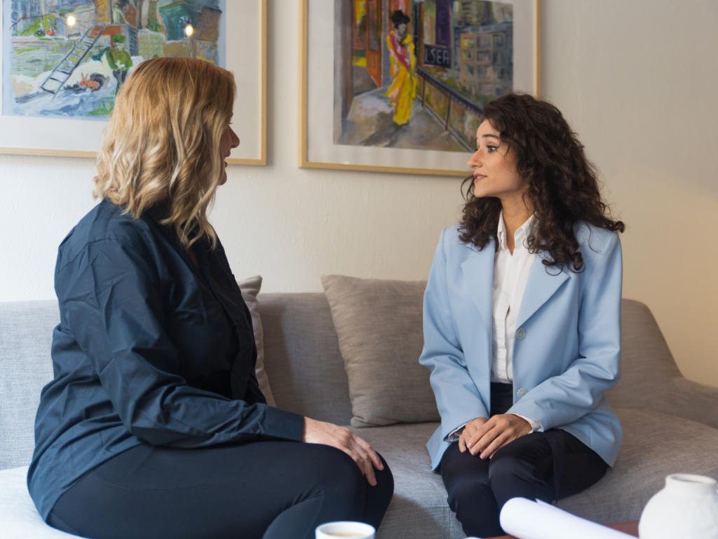 Two women in professional consultation discussing when natural sleep aids require expert medical guidance and treatment options