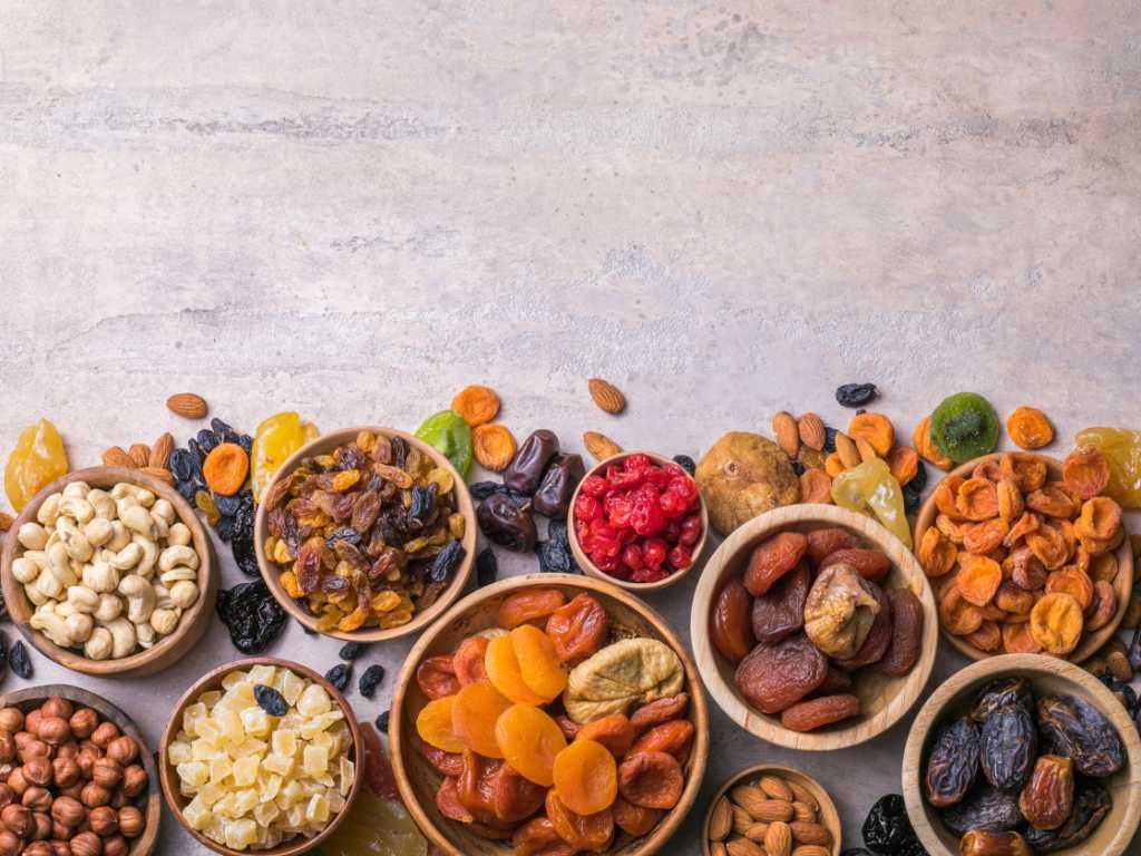 Assorted dried fruits and nuts in wooden bowls symbolizing smart eating habits and balanced nutrition.