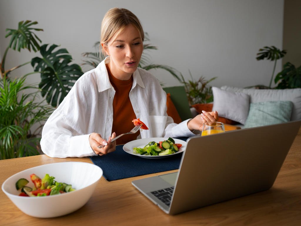 Woman practicing smart eating habits during a video call with a healthy meal
