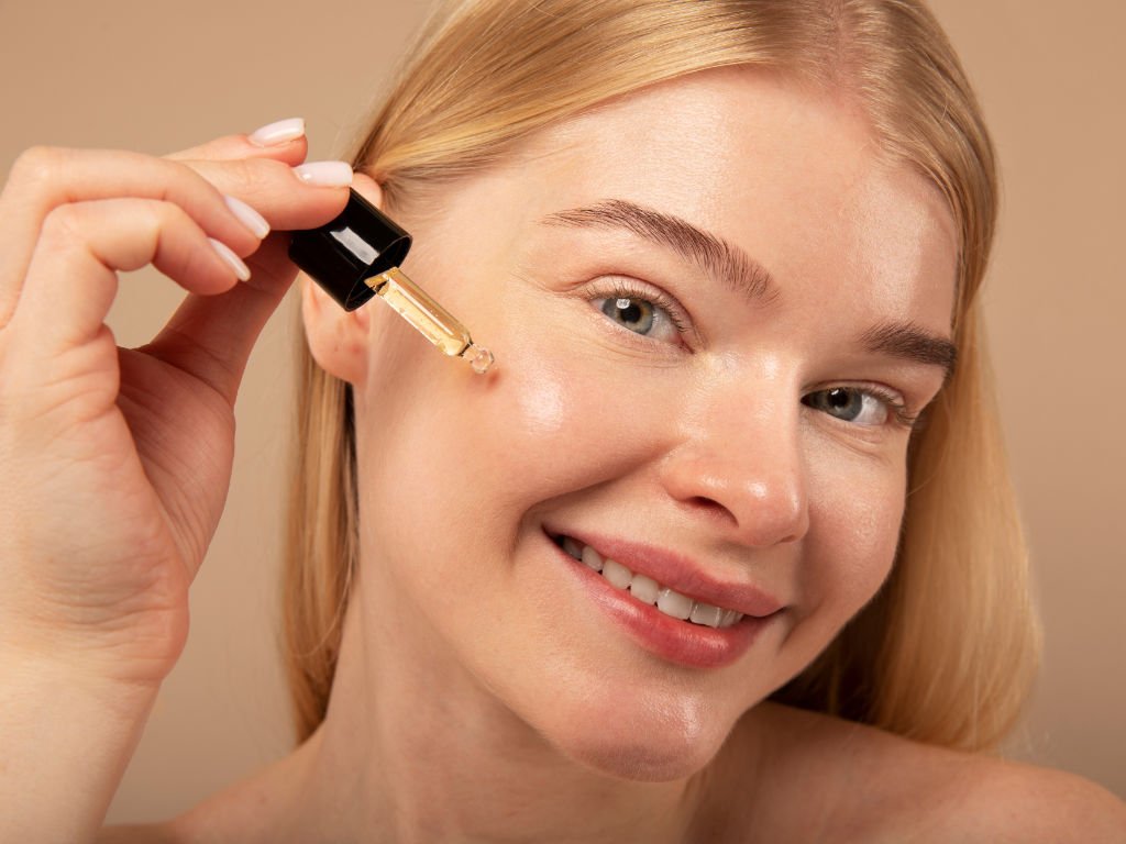 Woman applying targeted facial serum for age-specific anti-aging skincare strategies