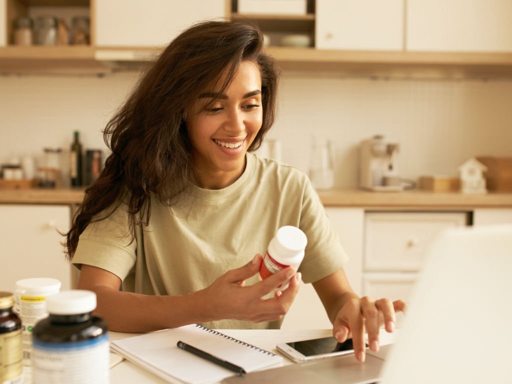 Woman researching and comparing different turmeric supplements while taking notes to make an informed choice about the best option