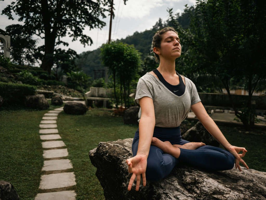 Woman practicing meditation in garden demonstrating hormonal balance tips through mind-body practices for natural wellness