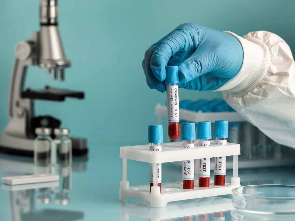 Laboratory technician selecting blood sample test tubes demonstrating how laboratory tests form the backbone of modern health diagnostics