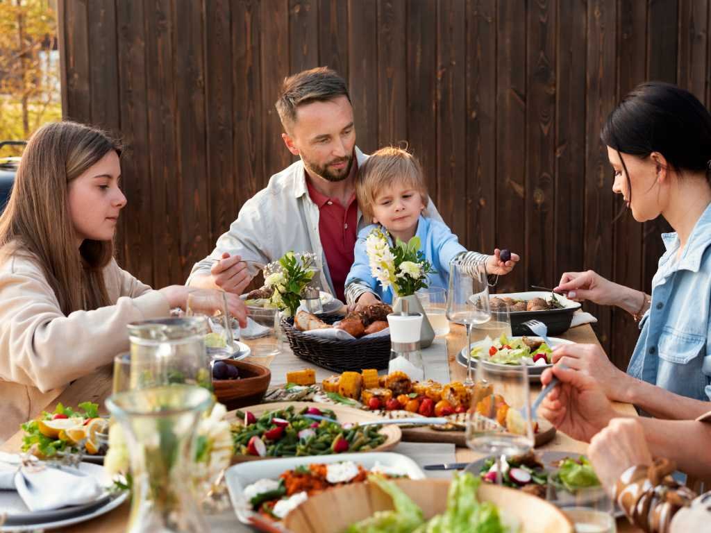 Mediterranean diet benefits include social connection through family meal sharing with multiple generations enjoying fresh foods together outdoors