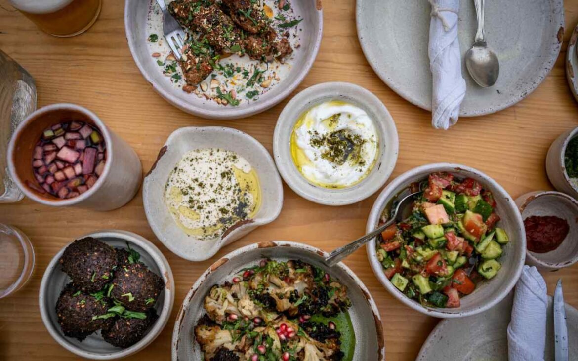 Mediterranean diet benefits showcase featuring fresh hummus, olive oil, grilled fish, colorful vegetables, and traditional Middle Eastern dishes arranged on rustic ceramic bowls