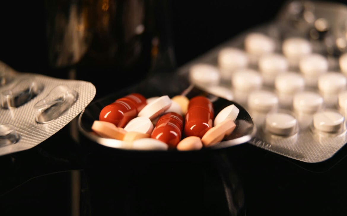 Various probiotics supplements capsules and tablets displayed on dark surface with blister packs, representing comprehensive scientific research into probiotic supplementation