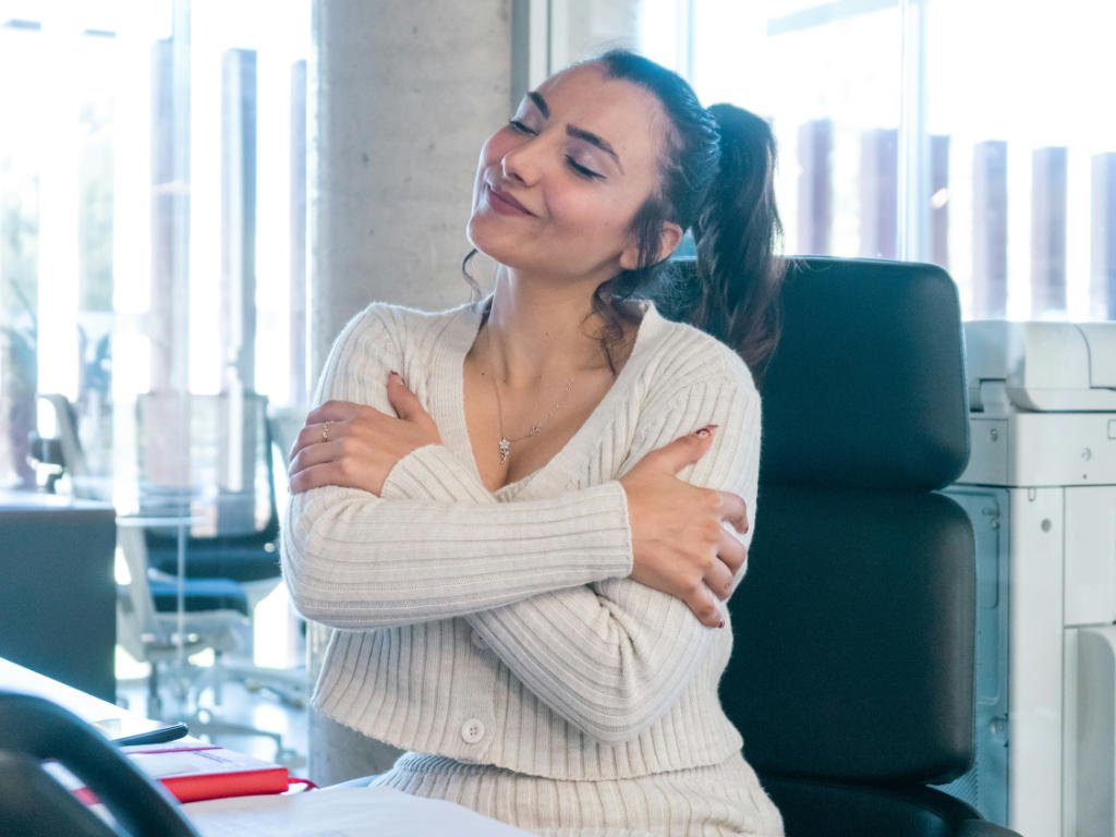 Professional woman practicing self-care in office environment as part of personal plan to combat stress and enhance wellness