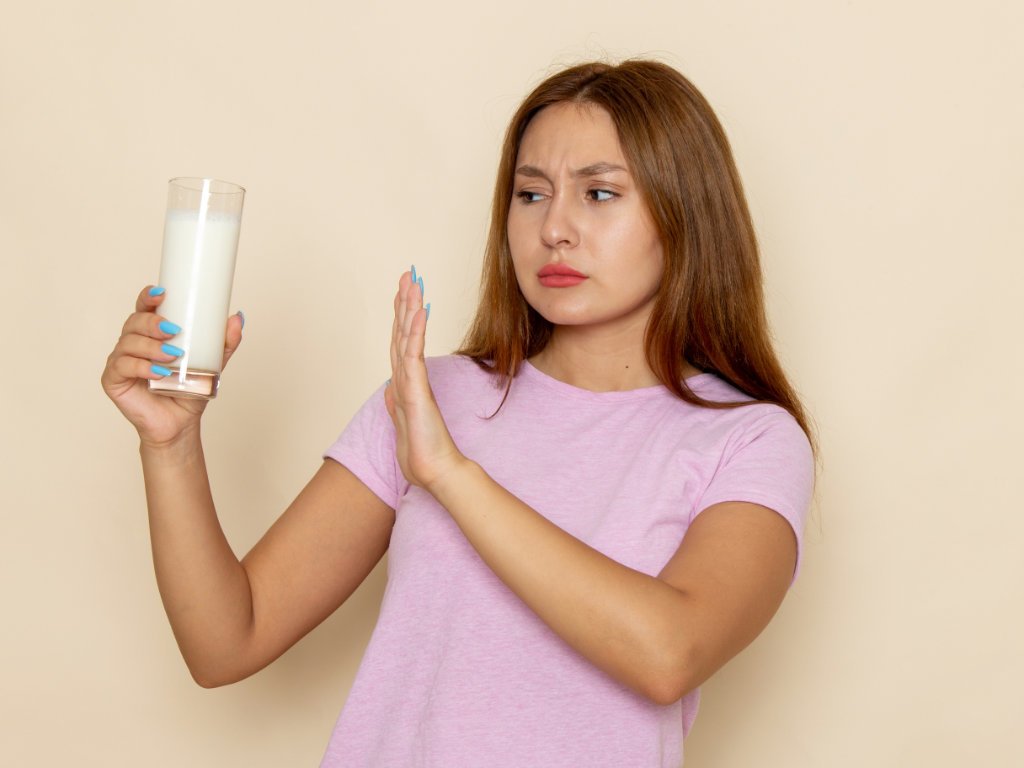 Woman refusing milk showing dairy avoidance mistakes when making smoothies for skin health and clear complexion