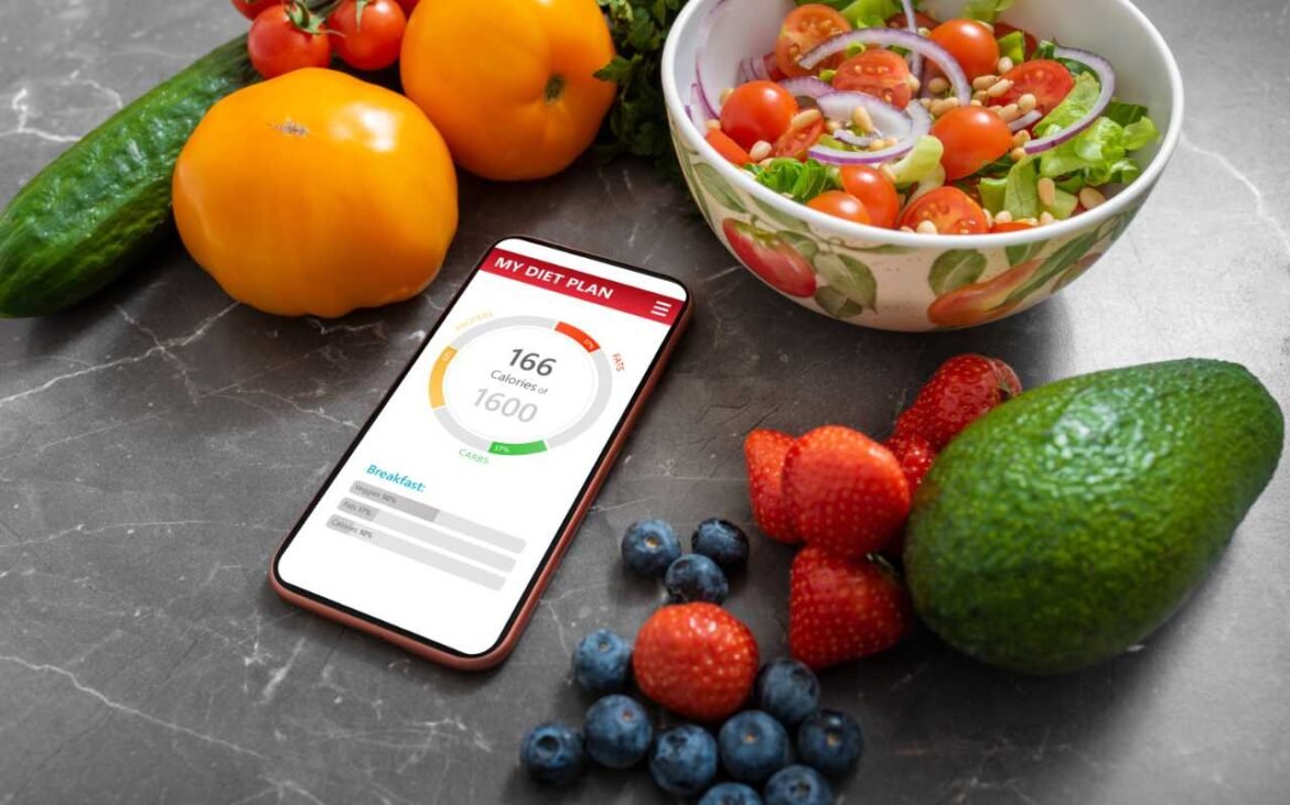 Meal planning made easy with fresh vegetables, healthy salad bowl, and smartphone nutrition app showing calorie tracking for optimal health