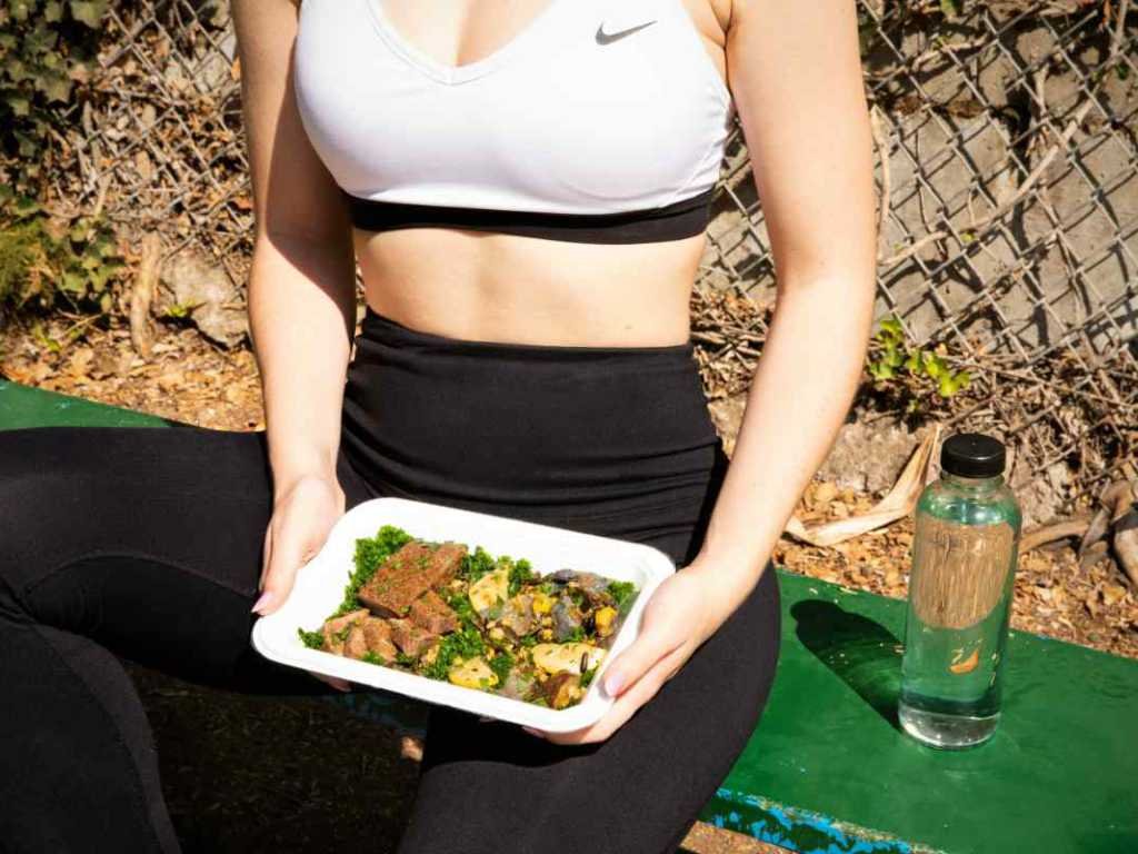 Woman enjoying healthy meal after workout showing positive real-world experience with natural weight loss supplements and lifestyle changes