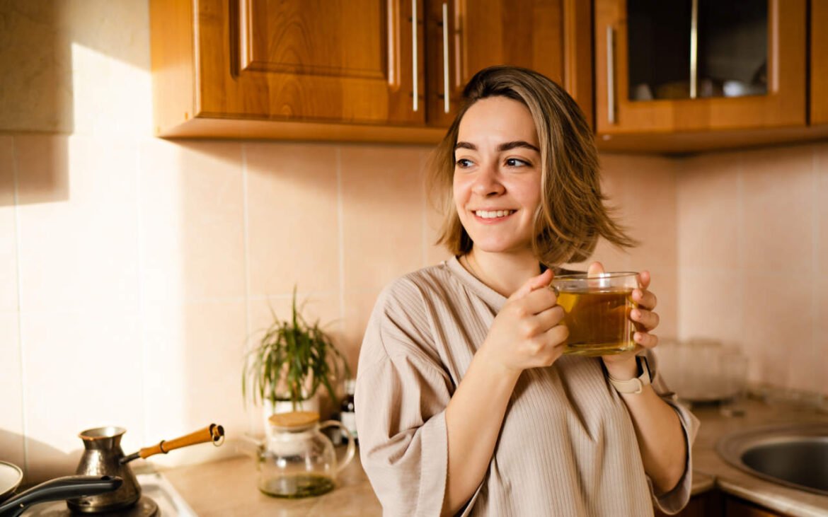Woman peacefully drinking herbal teas for focus in cozy kitchen environment promoting mental clarity and serenity