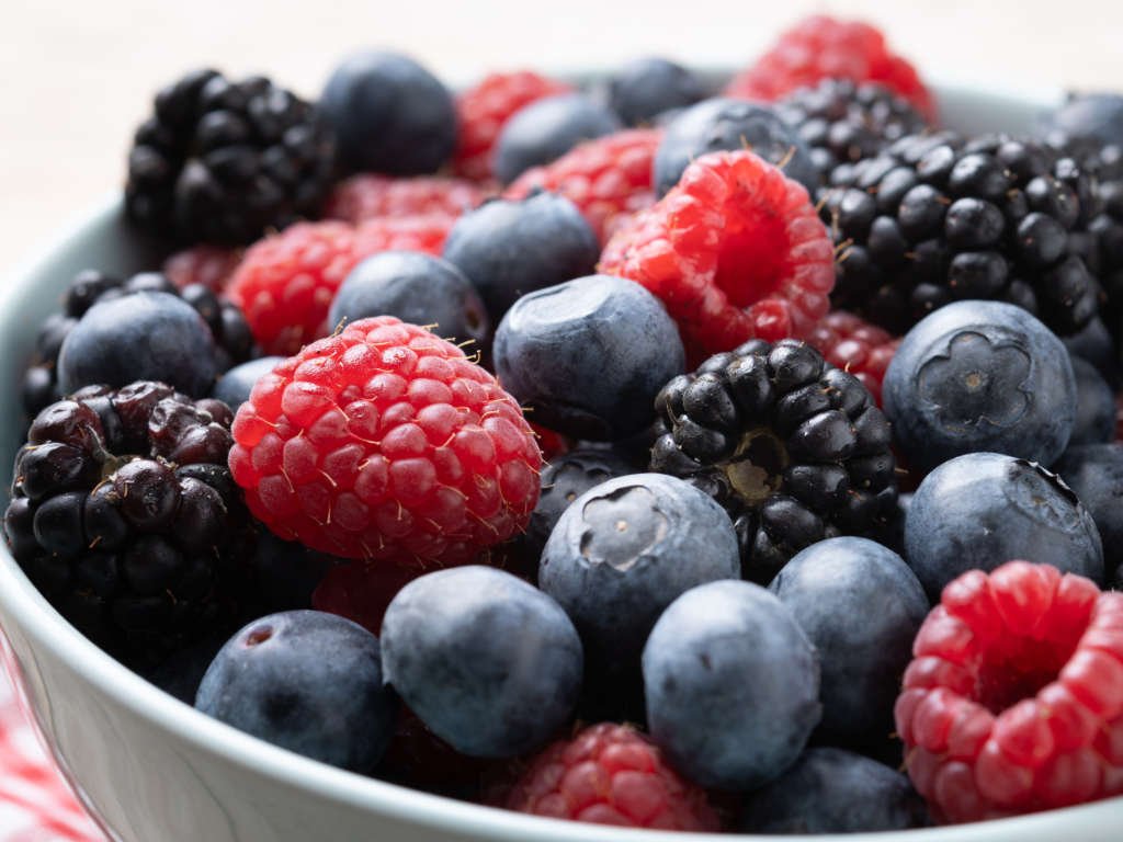Mixed berries superfoods for immunity including blueberries, raspberries, and blackberries in white bowl