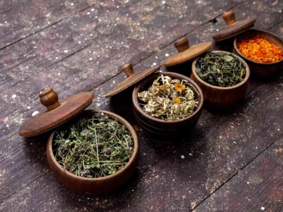 Collection of dried herbs and tea blends in wooden containers - staple foods for creating flavorful healthy meals