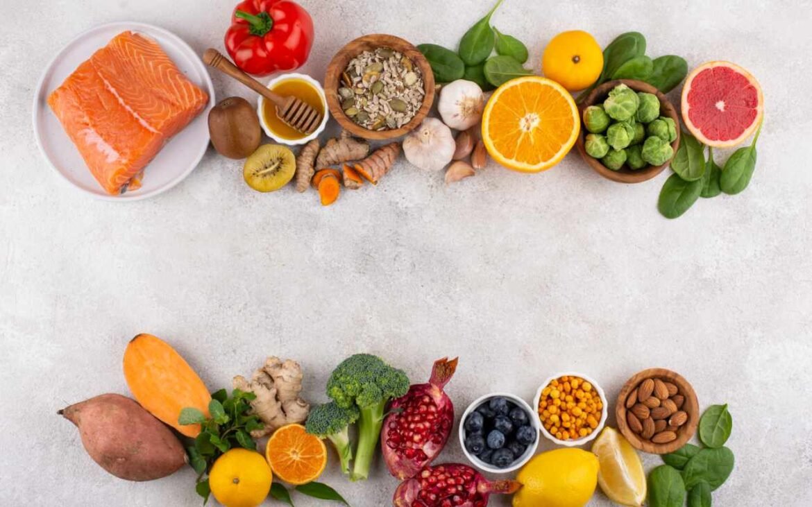 Colorful array of essential nutrients foods including salmon, citrus fruits, leafy greens, nuts, and vegetables arranged on white background for optimal physical and mental performance