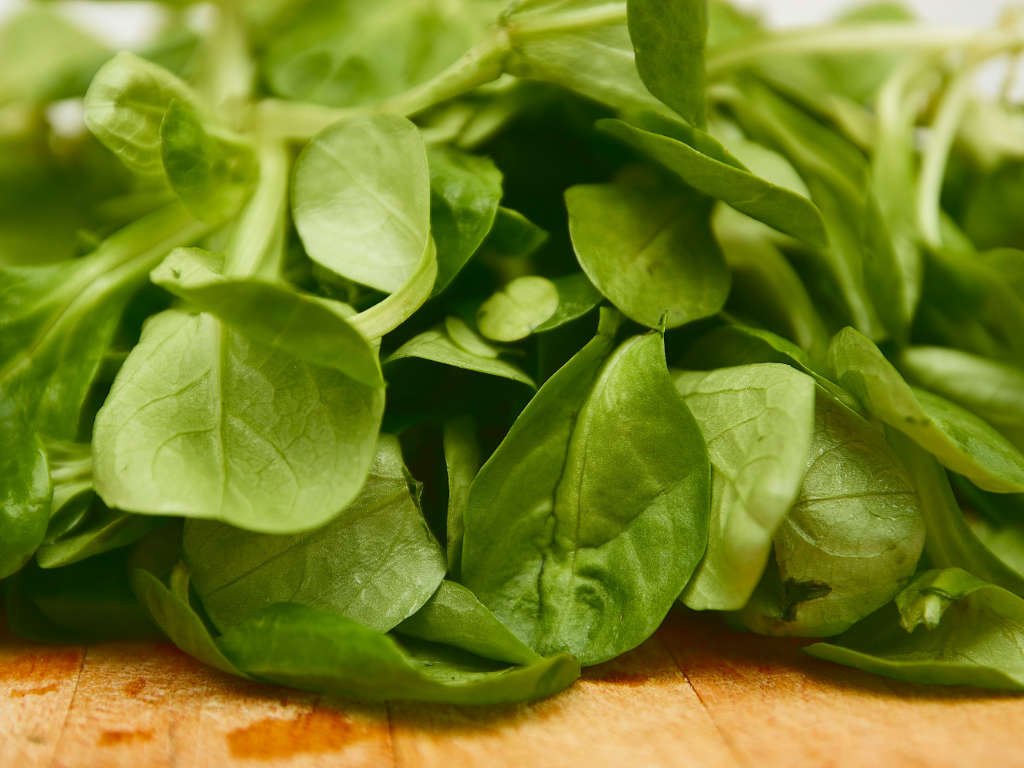 Fresh spinach leaves superfoods for immunity rich in iron and vitamins on wooden cutting board