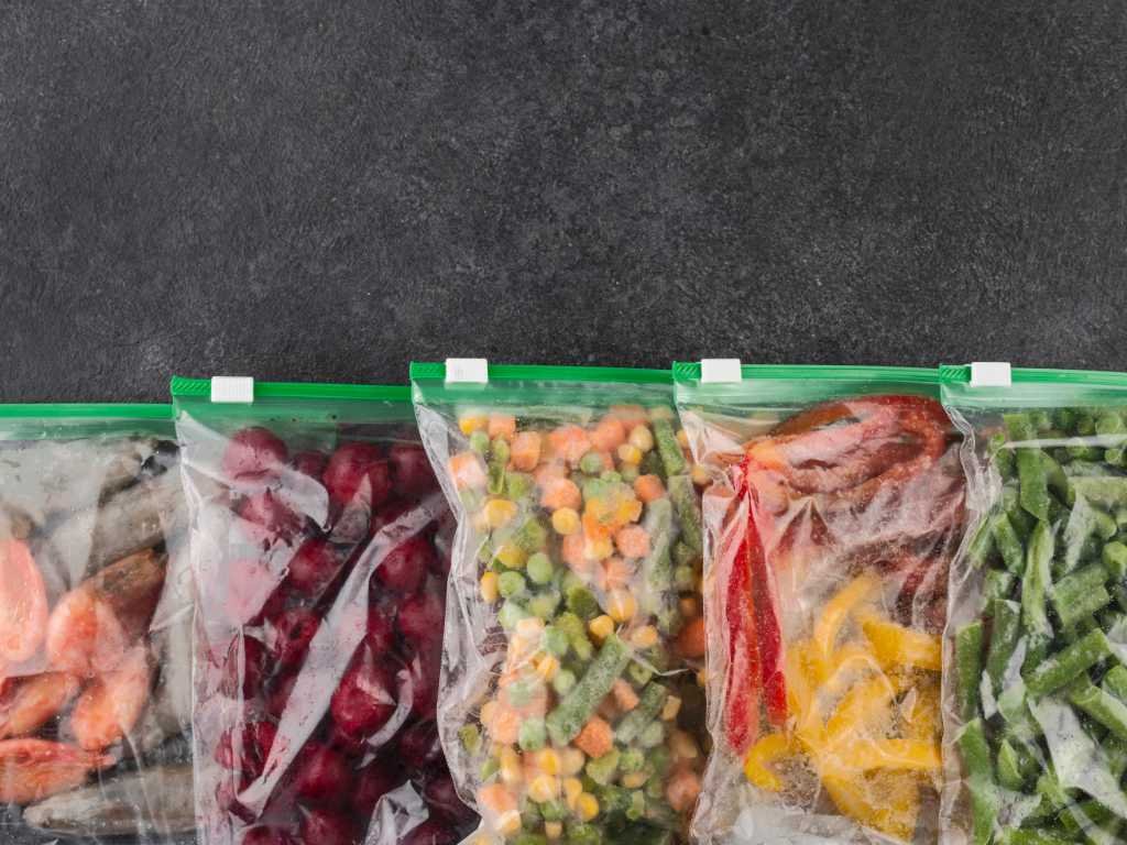 Variety of frozen vegetables in storage bags including mixed vegetables and greens - convenient staple foods for healthy meal preparation