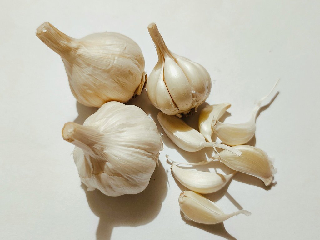 Fresh garlic bulbs and cloves superfoods for immunity with natural antimicrobial properties on white background