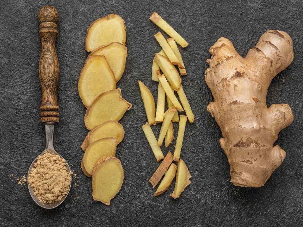 Fresh ginger root, sliced ginger, and ginger powder showing different forms of metabolism boosting spices for digestive health and fat burning