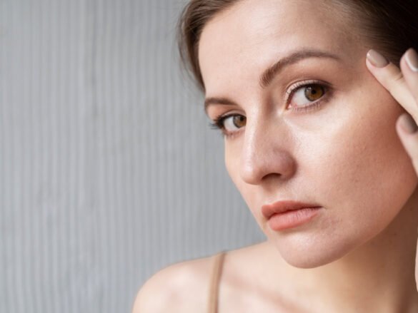 Woman analyzing her oily skin to discover effective hydration secrets for balanced beauty routine