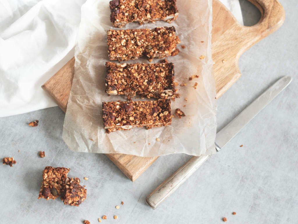 Crumbly homemade protein bars with visible crumbs on cutting board demonstrating texture issues