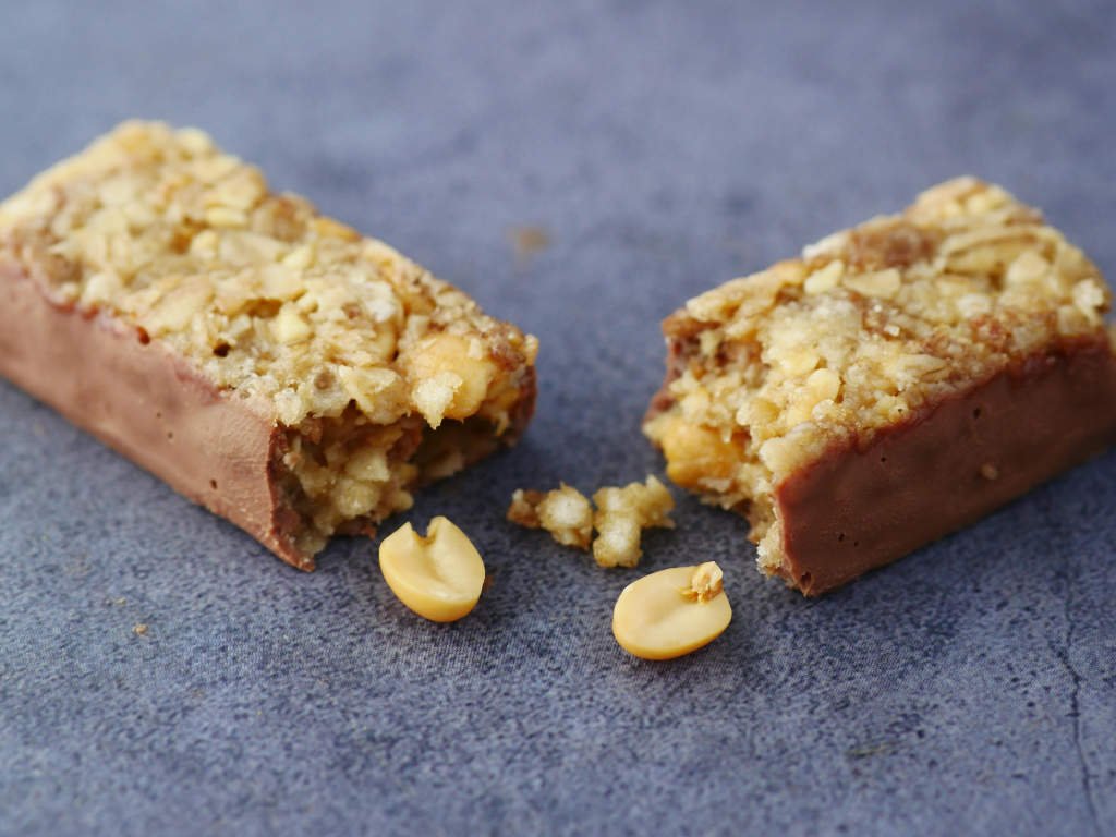 Cross-section of homemade protein bars showing creamy texture with rice crisps and peanuts