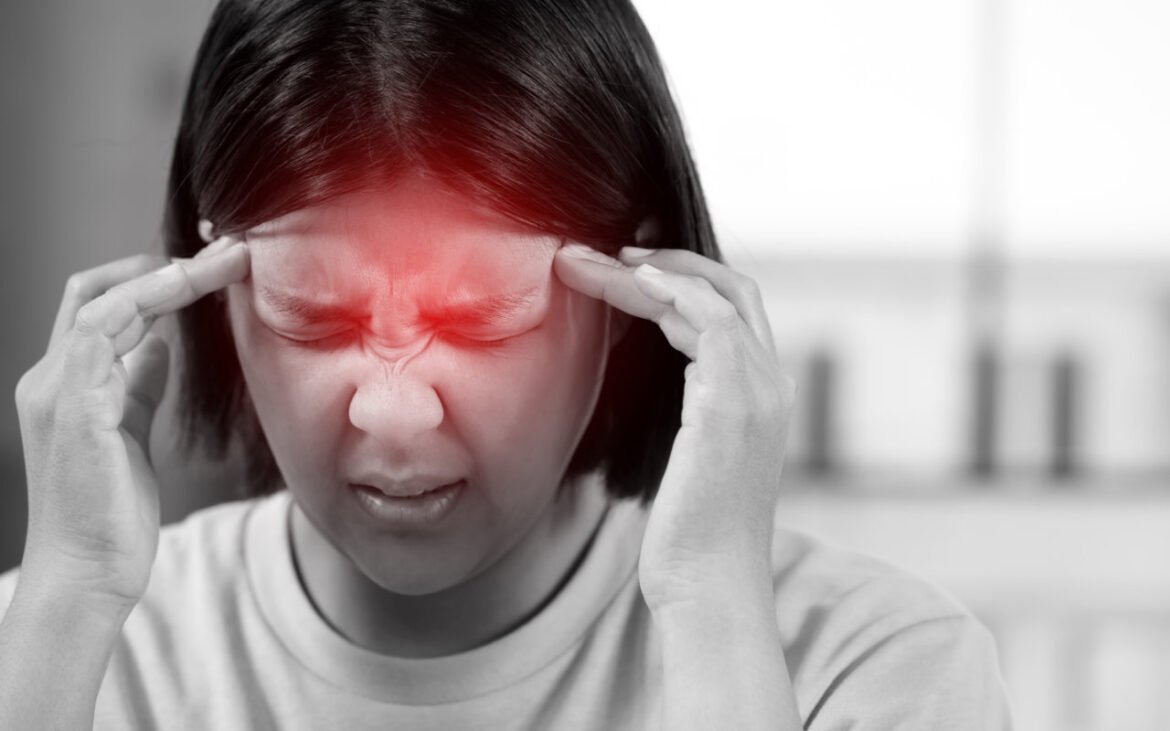 Woman experiencing severe headache holding temples showing need for magnesium for headaches relief